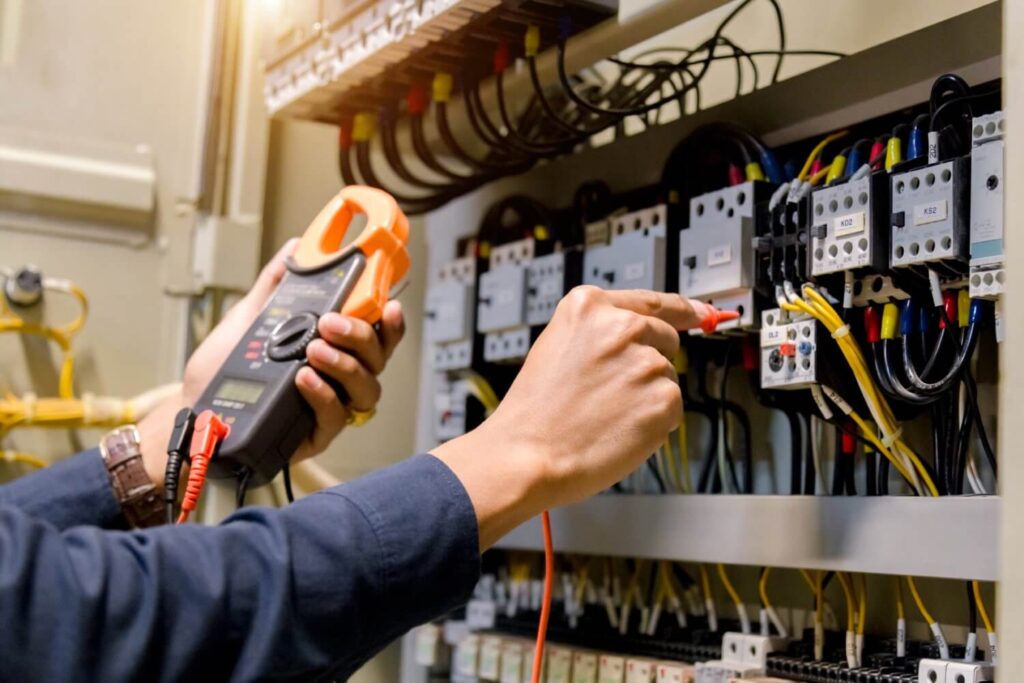 Electrician holding a tester for measuring voltage and current