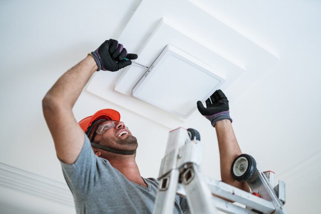 Electrician installing a led light on the ceiling